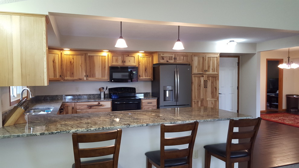 Eat-in kitchen - u-shaped dark wood floor eat-in kitchen idea with an undermount sink, stainless steel appliances and a peninsula