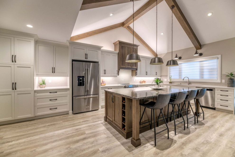 Inspiration for a transitional kitchen remodel with an undermount sink, shaker cabinets, quartz countertops, an island and stainless steel appliances