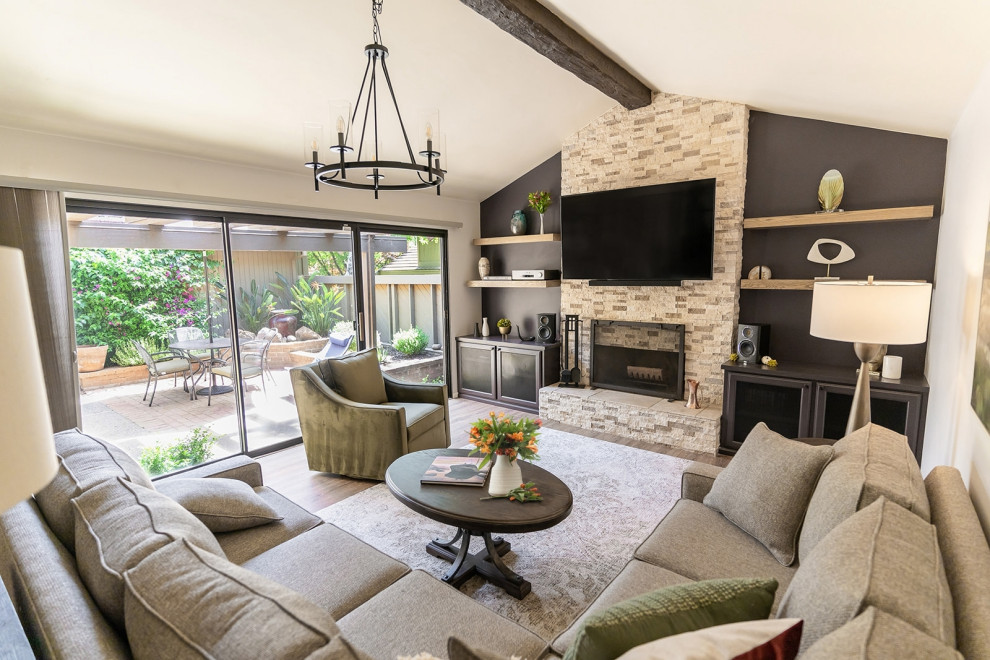 Inspiration for a medium sized classic open plan living room in Sacramento with a music area, grey walls, vinyl flooring, a standard fireplace, a stacked stone fireplace surround, a wall mounted tv, brown floors and exposed beams.