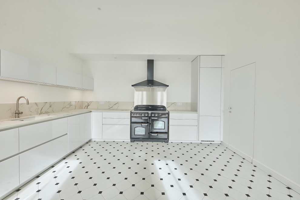 Photo of a large contemporary l-shaped separate kitchen with an integrated sink, flat-panel cabinets, white cabinets, quartz benchtops, white splashback, engineered quartz splashback, black appliances, ceramic floors, no island, black floor and white benchtop.
