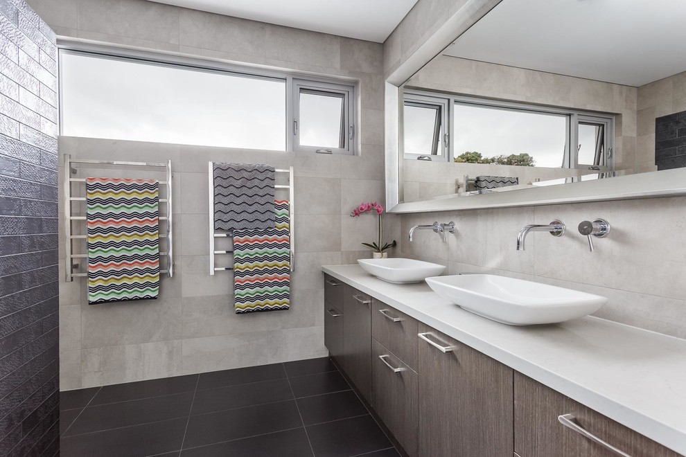Photo of a mid-sized contemporary kids bathroom in Perth with grey cabinets, an alcove shower, gray tile, ceramic tile, grey walls, ceramic floors, solid surface benchtops, grey floor and an open shower.