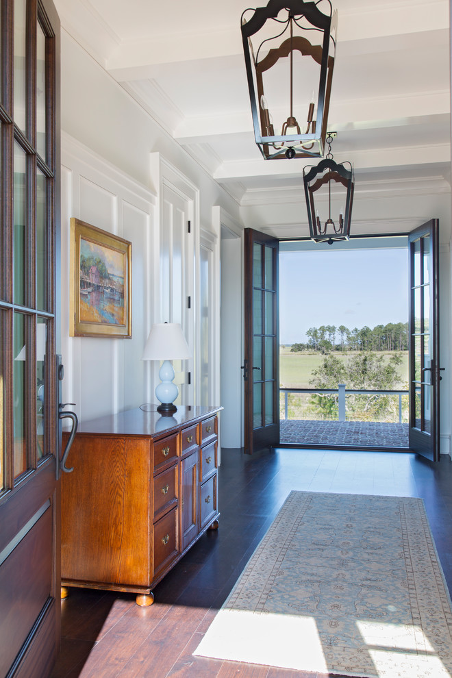 Photo of a large beach style hallway in Charleston with white walls, medium hardwood floors and brown floor.