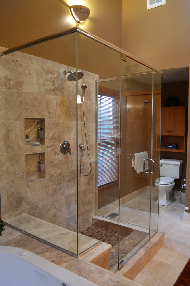 Design ideas for a mid-sized country master bathroom in Philadelphia with shaker cabinets, medium wood cabinets, a drop-in tub, an open shower, a two-piece toilet, brown tile, limestone, multi-coloured walls, travertine floors, an undermount sink, granite benchtops, beige floor and a hinged shower door.