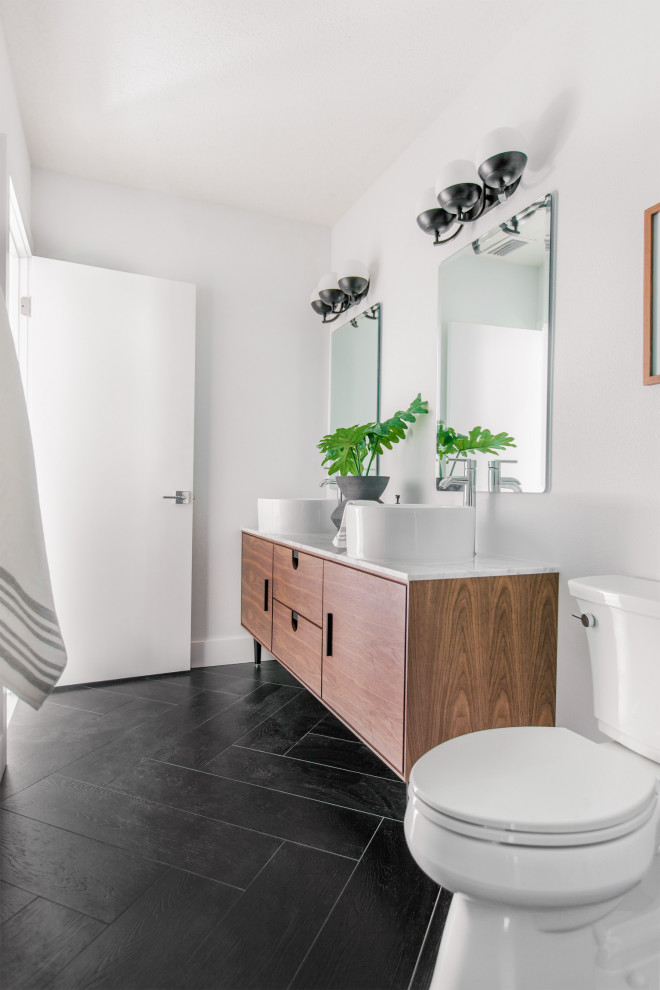 Inspiration for a small scandinavian master bathroom in Tampa with flat-panel cabinets, brown cabinets, an alcove shower, a one-piece toilet, white tile, subway tile, white walls, ceramic floors, a vessel sink, engineered quartz benchtops, black floor, a hinged shower door, white benchtops, a niche, a double vanity and a freestanding vanity.