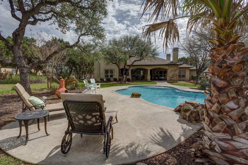 Large transitional backyard custom-shaped pool house photo in Austin with decking