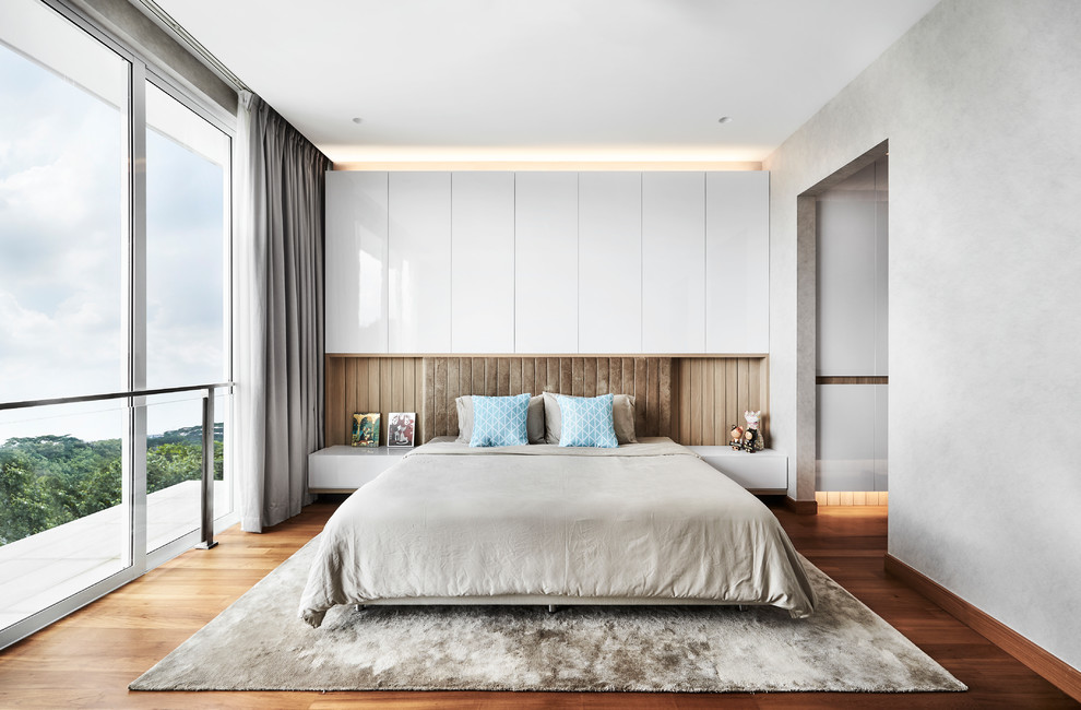This is an example of a contemporary bedroom in Singapore with grey walls, medium hardwood floors and brown floor.