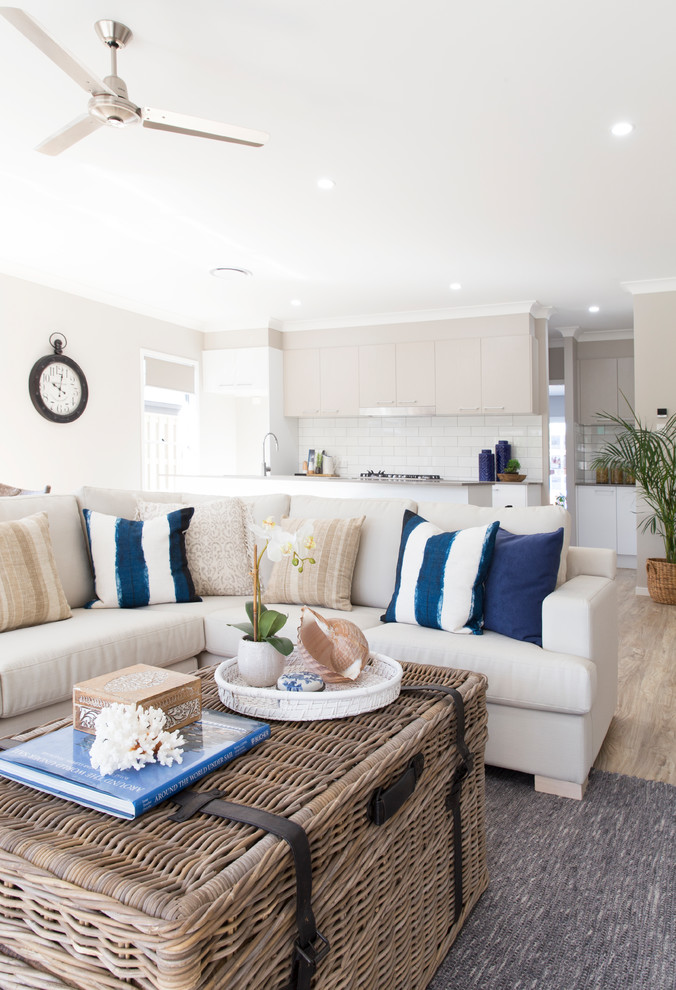 Large beach style open concept living room in Brisbane with white walls, vinyl floors and brown floor.