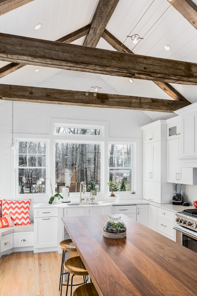 Design ideas for a mid-sized country l-shaped eat-in kitchen in New York with an undermount sink, beaded inset cabinets, white cabinets, quartz benchtops, stainless steel appliances, light hardwood floors and with island.
