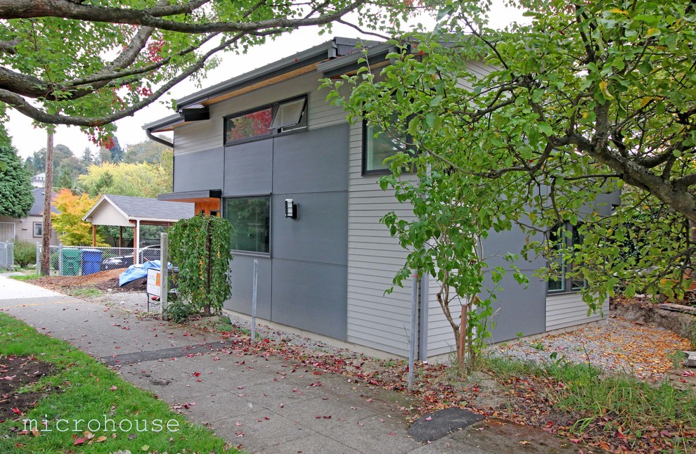 This is an example of a small transitional two-storey grey exterior in Seattle with concrete fiberboard siding and a shed roof.