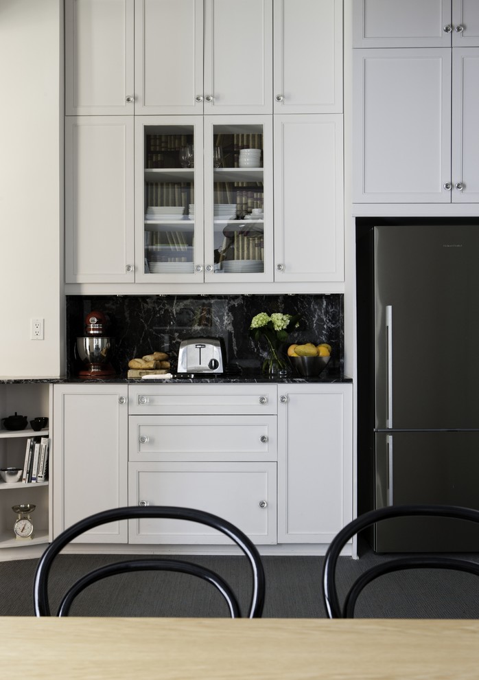This is an example of a small traditional separate kitchen in Montreal with a single-bowl sink, white cabinets, granite benchtops, black splashback, stone tile splashback, stainless steel appliances, carpet and no island.