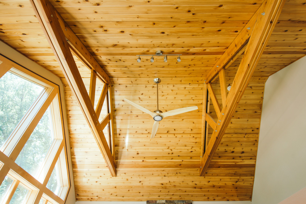 Inspiration pour une grande salle de séjour design ouverte avec un mur vert, un sol en bois brun, un poêle à bois, un sol marron et un plafond voûté.