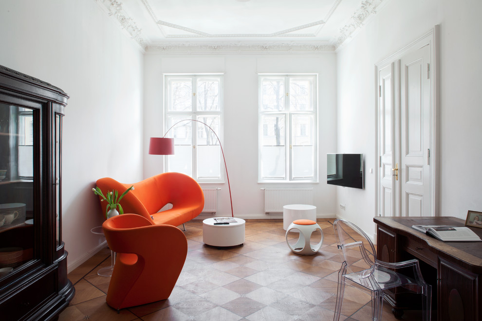 Inspiration for an eclectic enclosed living room in Berlin with white walls, medium hardwood floors, no fireplace and a wall-mounted tv.