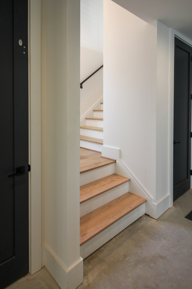 Idées déco pour un escalier droit contemporain de taille moyenne avec des marches en bois et un garde-corps en métal.