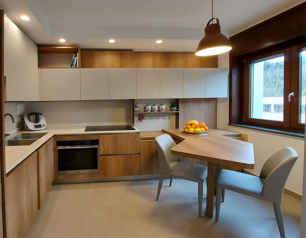 Foto di una cucina minimal di medie dimensioni con lavello sottopiano, paraspruzzi bianco, paraspruzzi in gres porcellanato, pavimento in gres porcellanato, penisola, pavimento grigio e top bianco