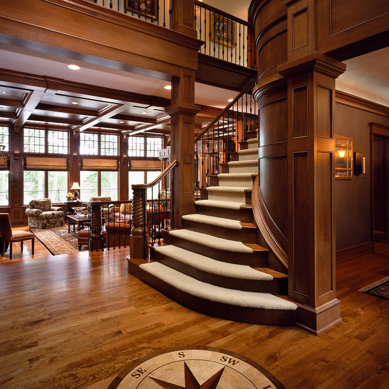 Example of a huge mountain style wooden curved medium tone wood floor staircase design in Boston with brown walls
