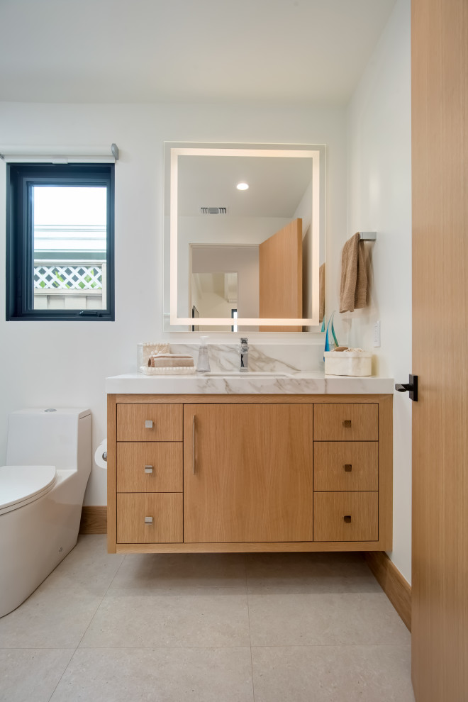 Photo of a small contemporary 3/4 bathroom in Los Angeles with beaded inset cabinets, light wood cabinets, a one-piece toilet, porcelain tile, white walls, an undermount sink, marble benchtops, white floor, a hinged shower door, white benchtops, a shower seat, a floating vanity, an alcove shower, gray tile, ceramic floors and a single vanity.