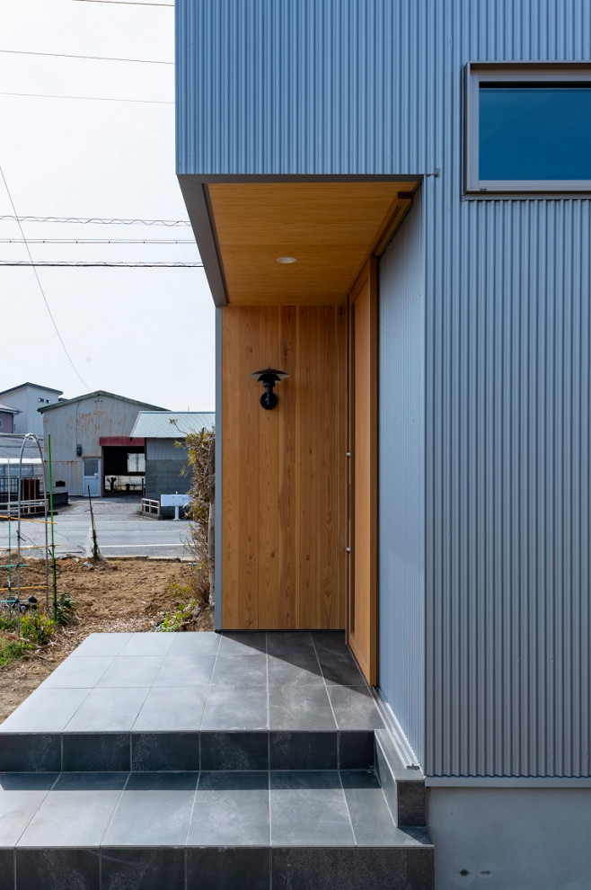 Esempio di una porta d'ingresso di medie dimensioni con pareti con effetto metallico, pavimento con piastrelle in ceramica, una porta scorrevole, una porta in legno bruno, pavimento grigio, soffitto in legno e boiserie