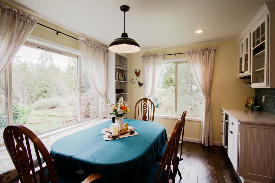 Mid-sized country open plan dining in Seattle with yellow walls and dark hardwood floors.