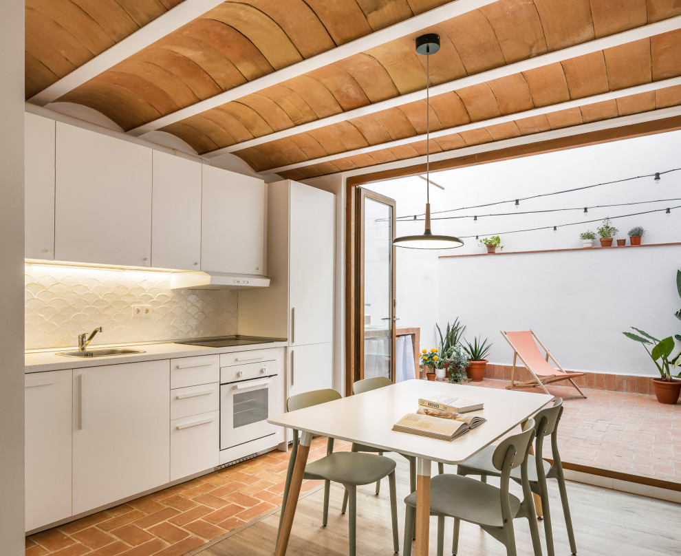 Exemple d'une petite salle à manger ouverte sur le salon méditerranéenne avec un mur blanc, sol en stratifié, aucune cheminée, un sol marron et poutres apparentes.