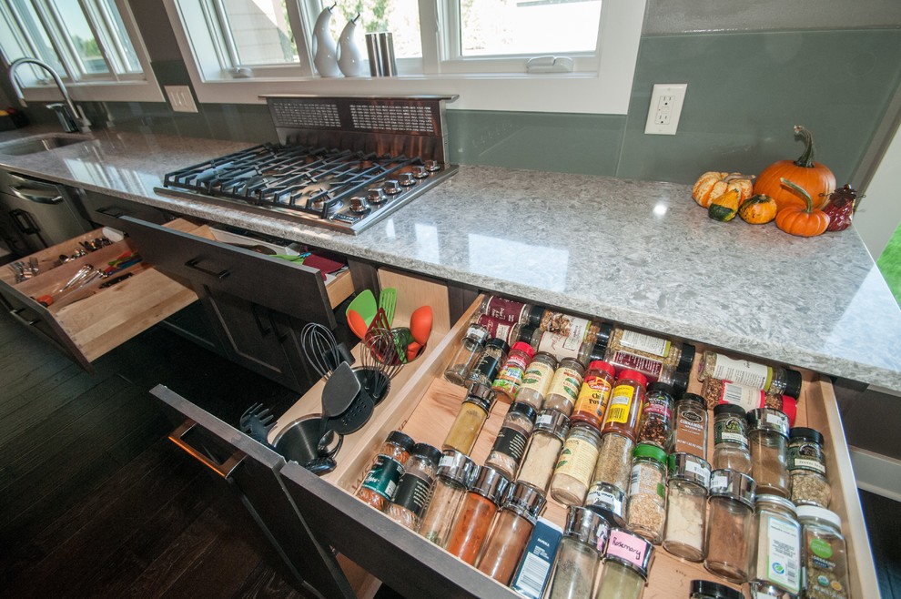 Inspiration for a large rustic dark wood floor and brown floor eat-in kitchen remodel with an undermount sink, flat-panel cabinets, medium tone wood cabinets, quartz countertops, green backsplash, glass sheet backsplash, stainless steel appliances and an island