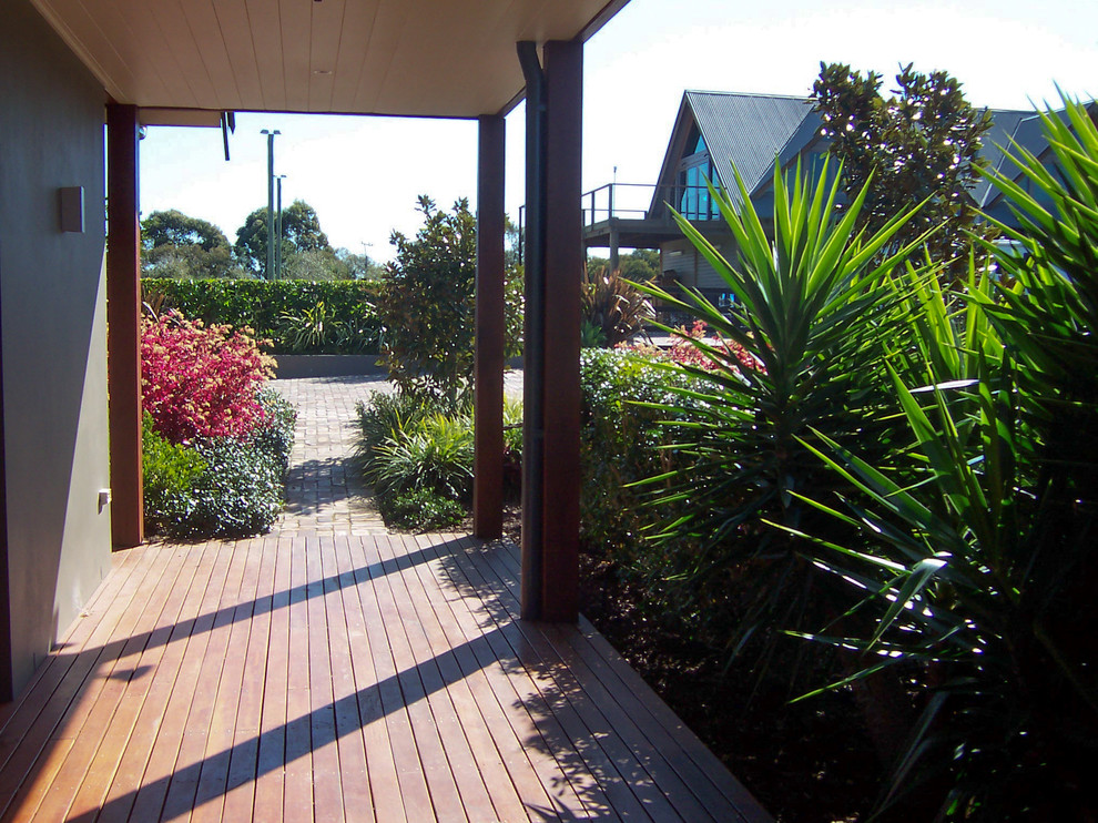 Photo of a tropical front yard partial sun garden for spring in Sydney with a garden path and decking.