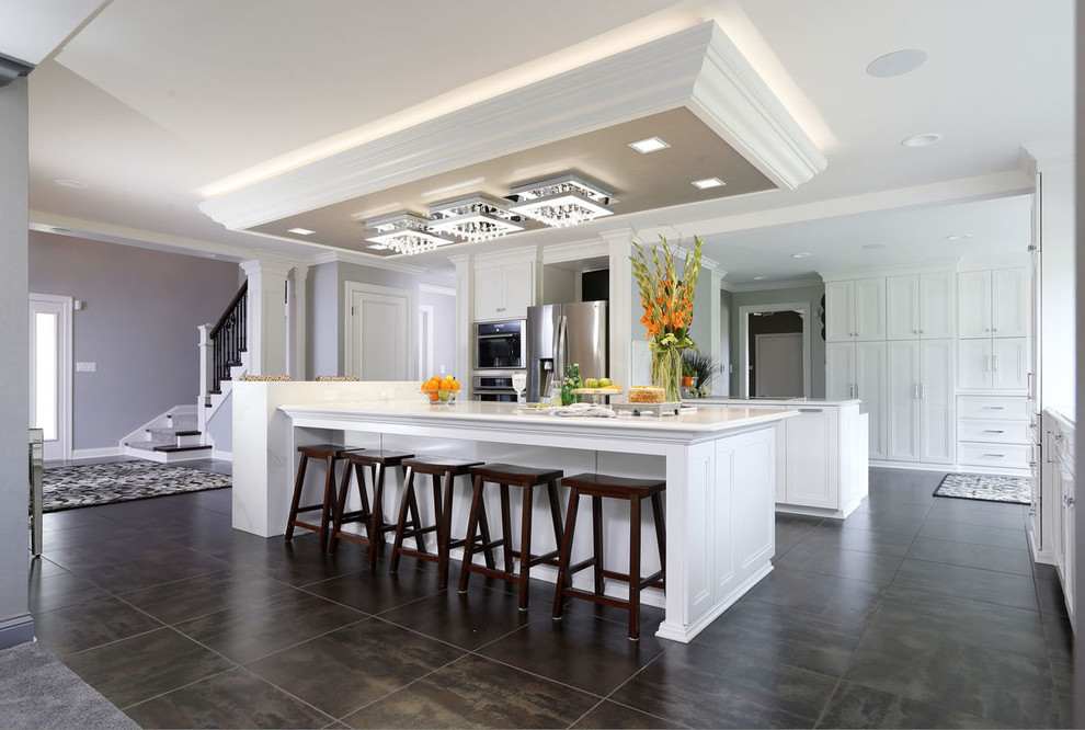 Inspiration for a transitional porcelain tile and gray floor kitchen remodel in Cedar Rapids with recessed-panel cabinets, white cabinets, glass countertops, stainless steel appliances, two islands and white countertops