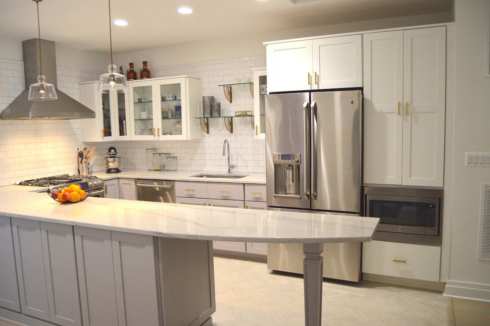 Photo of a small transitional u-shaped open plan kitchen in DC Metro with an undermount sink, shaker cabinets, grey cabinets, quartzite benchtops, white splashback, ceramic splashback, stainless steel appliances, ceramic floors and a peninsula.