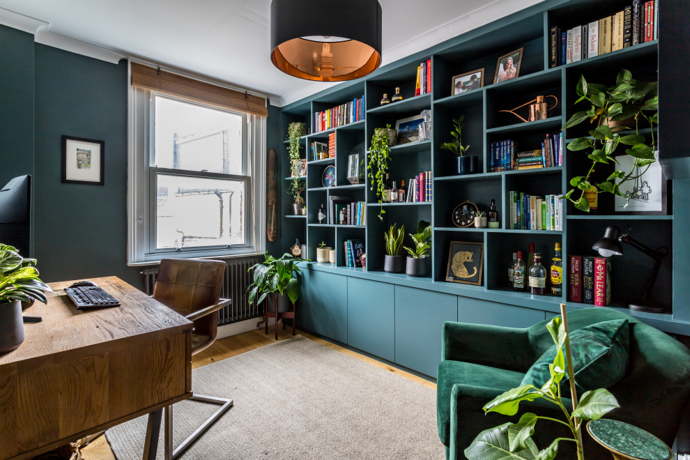 Inspiration for a medium sized study in London with blue walls, medium hardwood flooring, a freestanding desk and brown floors.