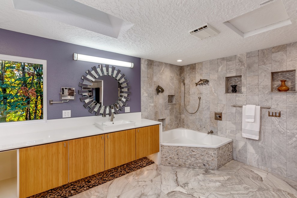 На фото: большая главная ванная комната в стиле модернизм с плоскими фасадами, светлыми деревянными фасадами, угловым душем, унитазом-моноблоком, фиолетовыми стенами, полом из травертина, накладной раковиной, столешницей из искусственного кварца, серым полом, открытым душем и белой столешницей