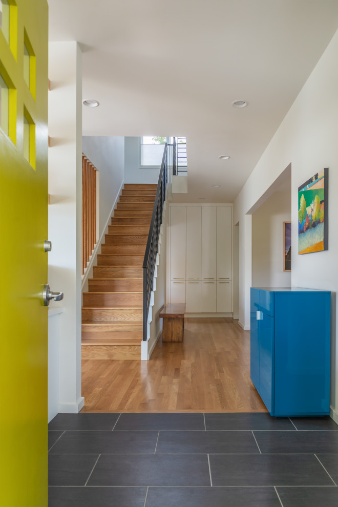 Design ideas for a mid-sized contemporary foyer in Seattle with white walls, ceramic floors, a single front door, a yellow front door and black floor.