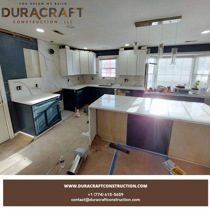 Eat-in kitchen - large l-shaped vinyl floor and gray floor eat-in kitchen idea with stainless steel appliances, an island, a single-bowl sink, green cabinets, quartz countertops, white backsplash, quartz backsplash and white countertops