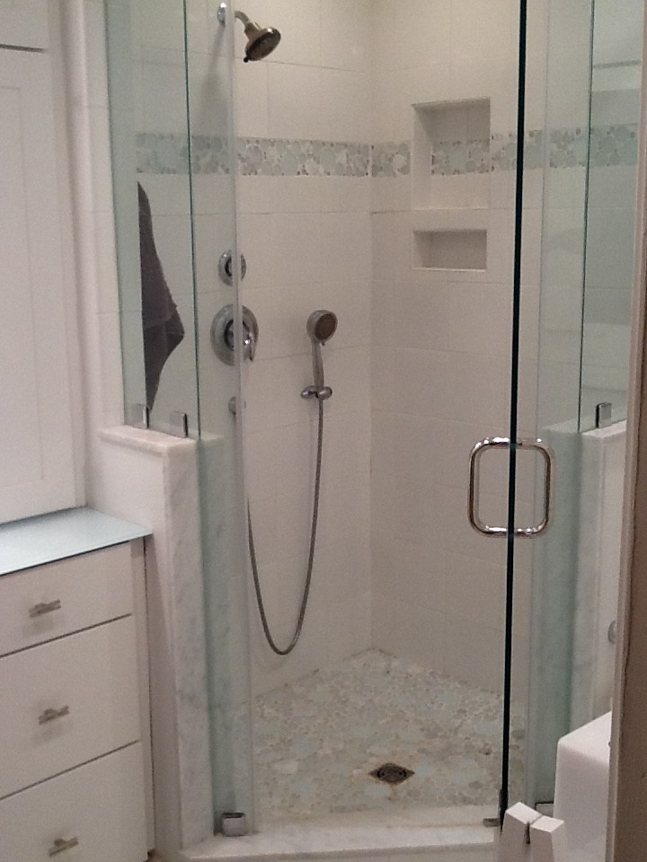 This is an example of a mid-sized eclectic master bathroom in Philadelphia with white cabinets, a corner shower, a two-piece toilet, blue tile, gray tile, a drop-in sink, glass benchtops, white floor, a hinged shower door, recessed-panel cabinets, ceramic tile, beige walls, porcelain floors and green benchtops.