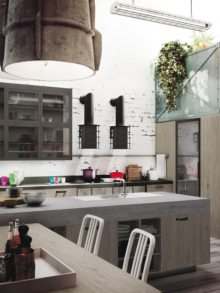 Photo of a mid-sized industrial l-shaped open plan kitchen in Marseille with an integrated sink, glass-front cabinets, light wood cabinets, concrete benchtops, grey splashback, cement tile splashback, black appliances, painted wood floors and with island.