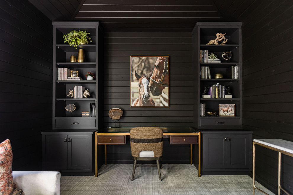 Inredning av ett lantligt litet hemmabibliotek, med svarta väggar, heltäckningsmatta, ett inbyggt skrivbord och flerfärgat golv