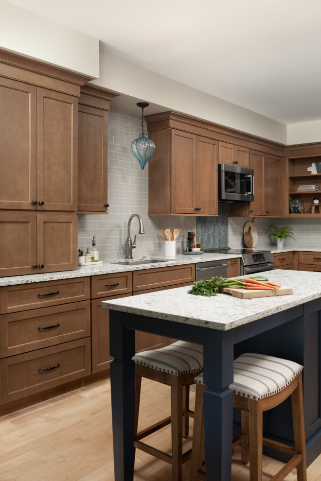 Medium sized classic galley kitchen/diner in Chicago with a double-bowl sink, flat-panel cabinets, medium wood cabinets, engineered stone countertops, grey splashback, ceramic splashback, stainless steel appliances, light hardwood flooring, an island and beige worktops.