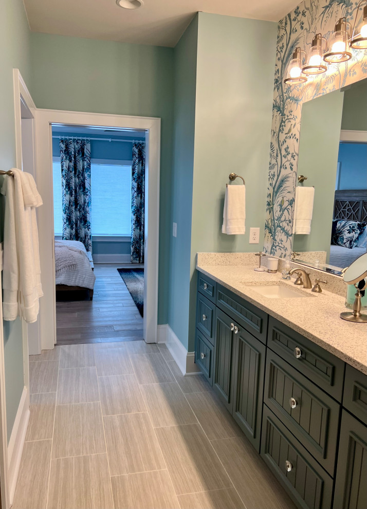 Inspiration for an expansive beach style bathroom in Other with recessed-panel cabinets, blue cabinets, a curbless shower, gray tile, ceramic tile, blue walls, medium hardwood floors, an undermount sink, engineered quartz benchtops, grey floor, a sliding shower screen, blue benchtops, a double vanity, a built-in vanity and wallpaper.