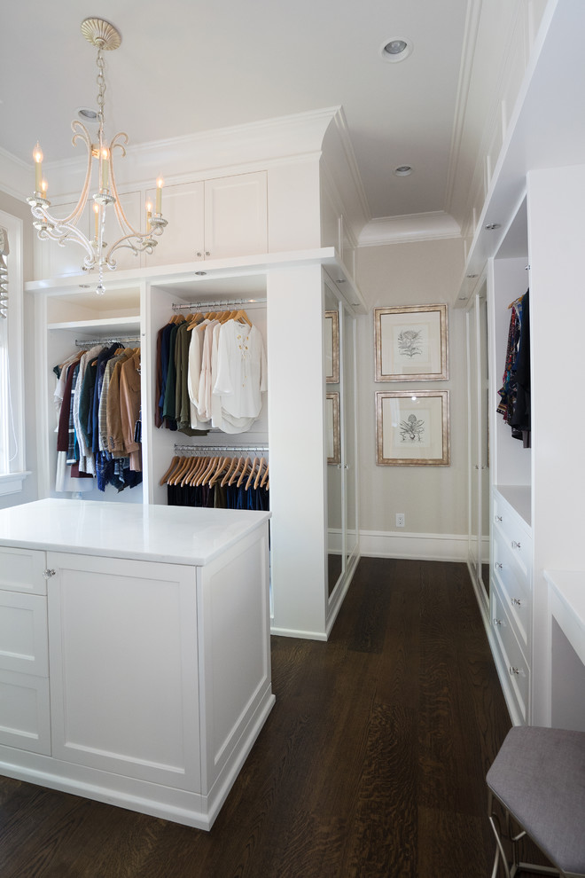 This is an example of a transitional women's storage and wardrobe in Other with glass-front cabinets and white cabinets.