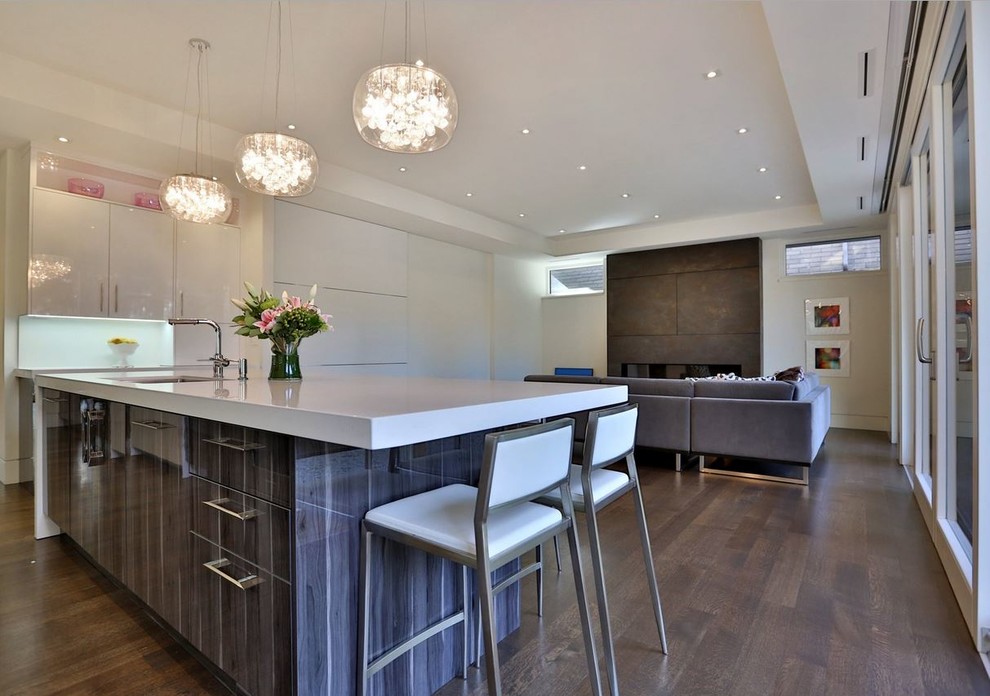 Photo of a mid-sized contemporary l-shaped eat-in kitchen in Toronto with an undermount sink, flat-panel cabinets, white cabinets, white splashback, stainless steel appliances, dark hardwood floors and with island.