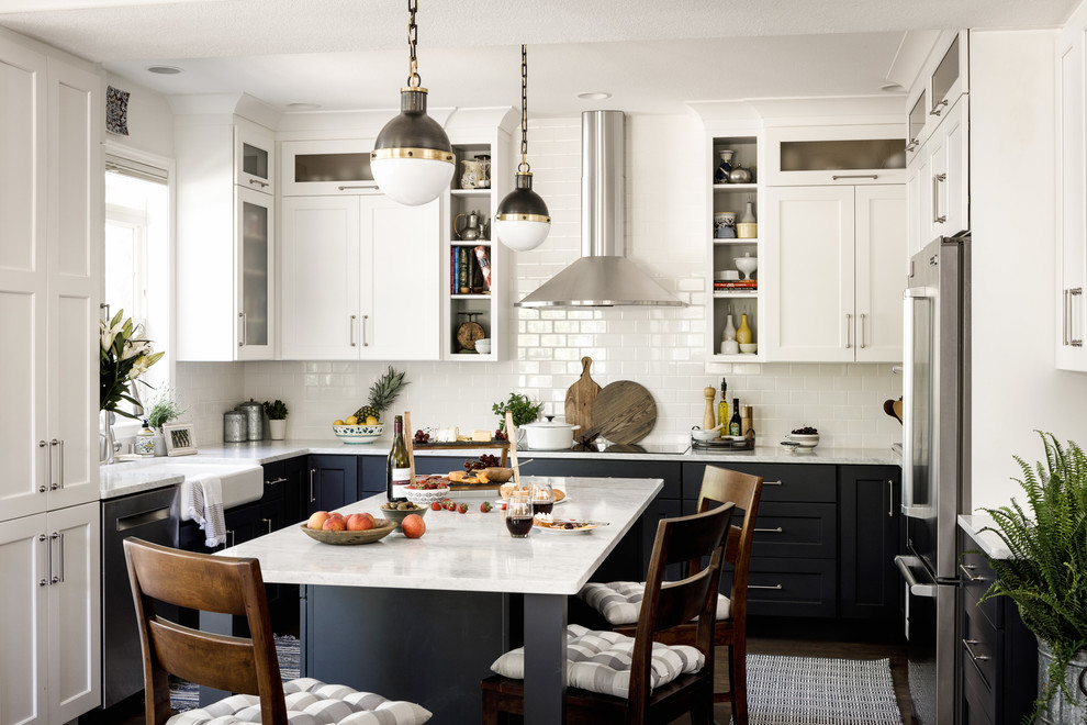 Design ideas for a transitional u-shaped eat-in kitchen in Denver with a farmhouse sink, shaker cabinets, white splashback, subway tile splashback, stainless steel appliances and with island.