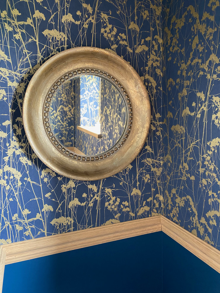 Diseño de aseo flotante contemporáneo pequeño con sanitario de una pieza, paredes azules, suelo de piedra caliza, lavabo suspendido, suelo beige y papel pintado