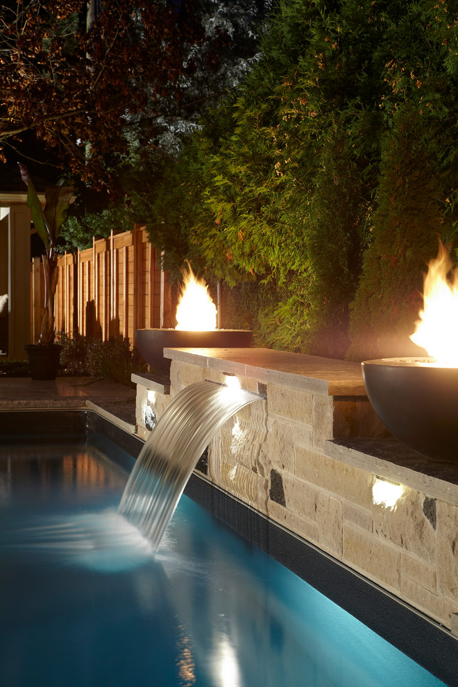Inspiration for a small modern backyard custom-shaped natural pool in Toronto with a water feature and brick pavers.