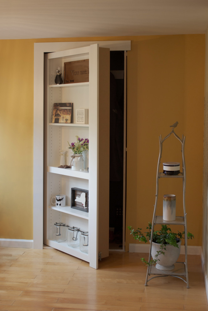 Photo of a small transitional foyer in New York with yellow walls and light hardwood floors.