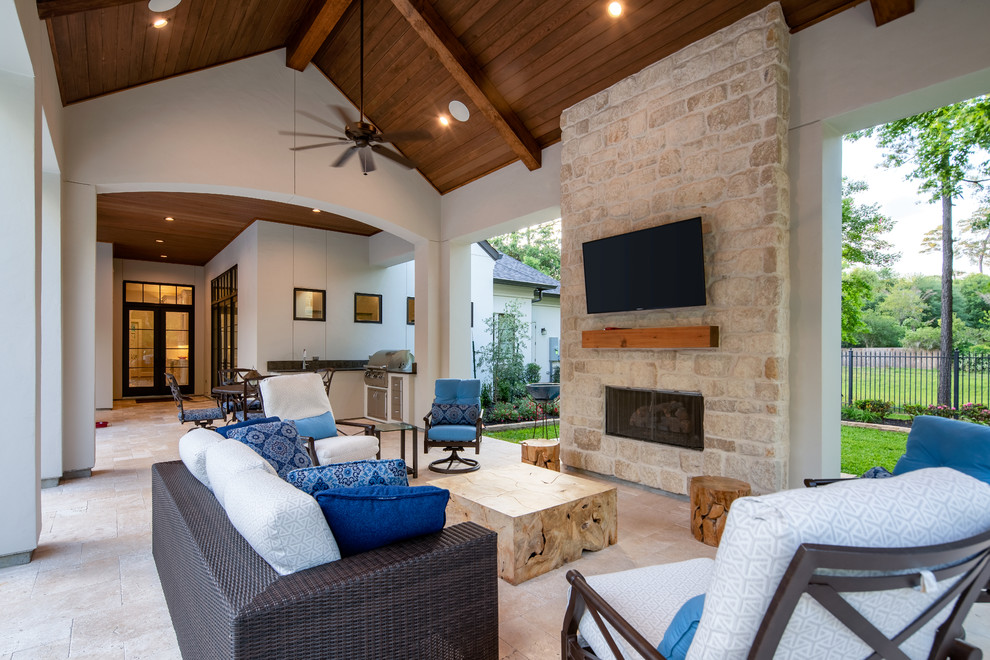 Photo of an expansive transitional backyard patio in Houston with with fireplace, tile and a roof extension.