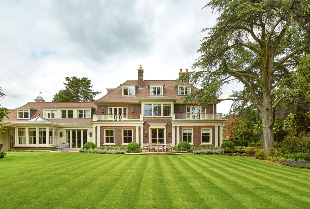 Design ideas for a traditional two-storey brick brown exterior in Surrey with a hip roof.