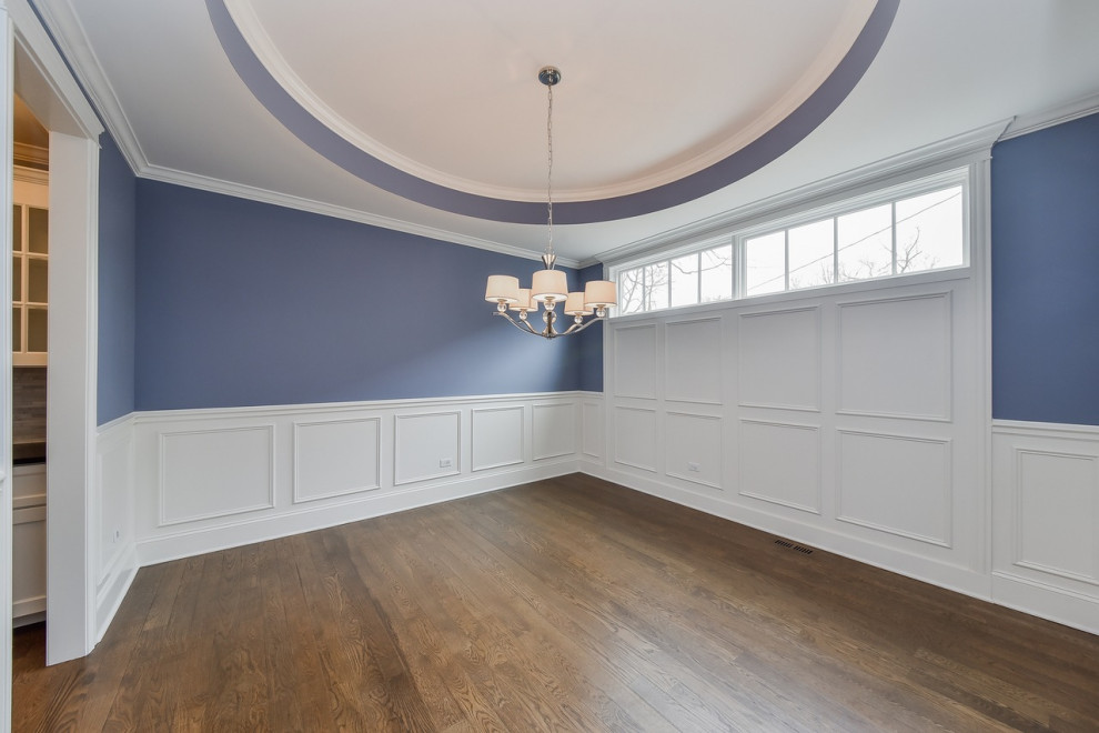 Cette image montre une salle à manger rustique fermée et de taille moyenne avec un mur bleu, un sol en bois brun, aucune cheminée, un sol marron, un plafond décaissé et boiseries.