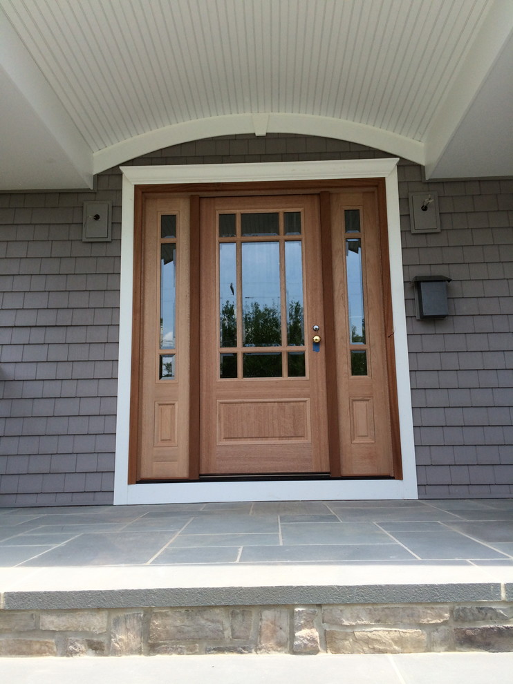 Photo of a mid-sized traditional entryway in New York with grey walls, slate floors, a single front door and a medium wood front door.