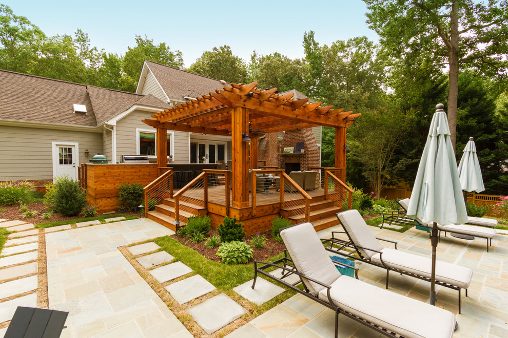 Design ideas for a mid-sized transitional backyard deck in Charlotte with a fire feature and a pergola.