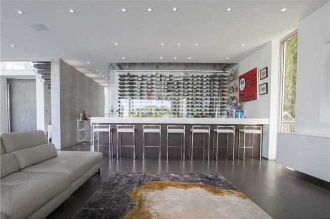 Inspiration for a large modern wine cellar in Miami with concrete floors, display racks and brown floor.