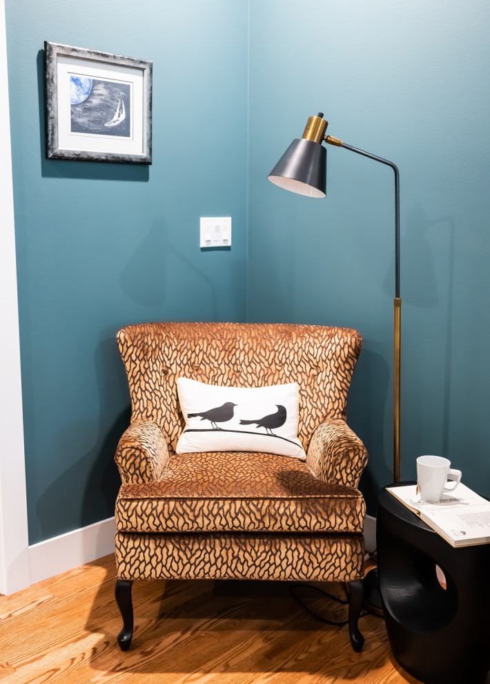 Imagen de estudio minimalista de tamaño medio con paredes azules, suelo de madera en tonos medios y suelo marrón