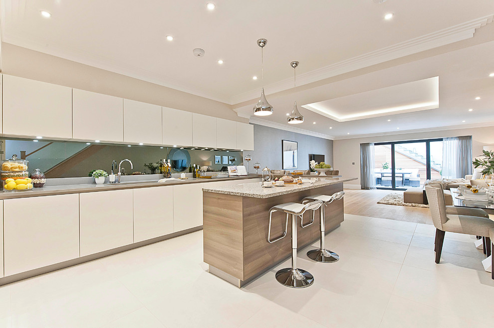 This is an example of a contemporary galley kitchen in Surrey with flat-panel cabinets and with island.